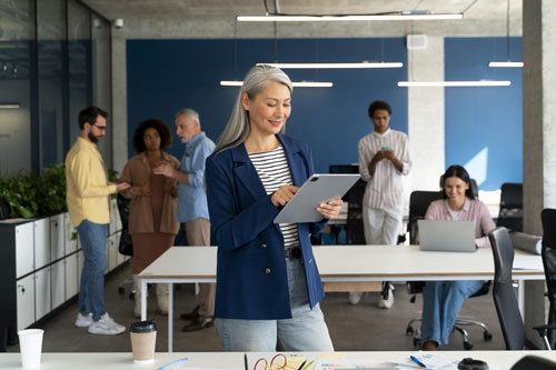 mulher empresária líder feliz ao fundo sua equipe trabalha com propósito